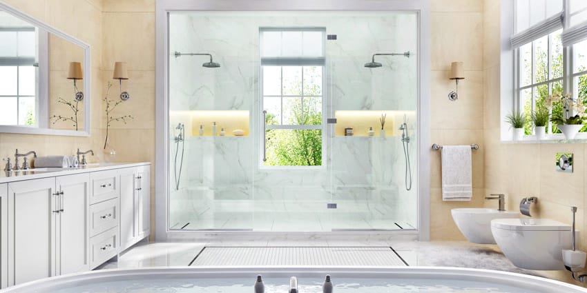 Просторная ванная комната с душевой стеной из каменной смолы, стеклянной дверью, столешницей, туалетом, зеркалами и окнами.
