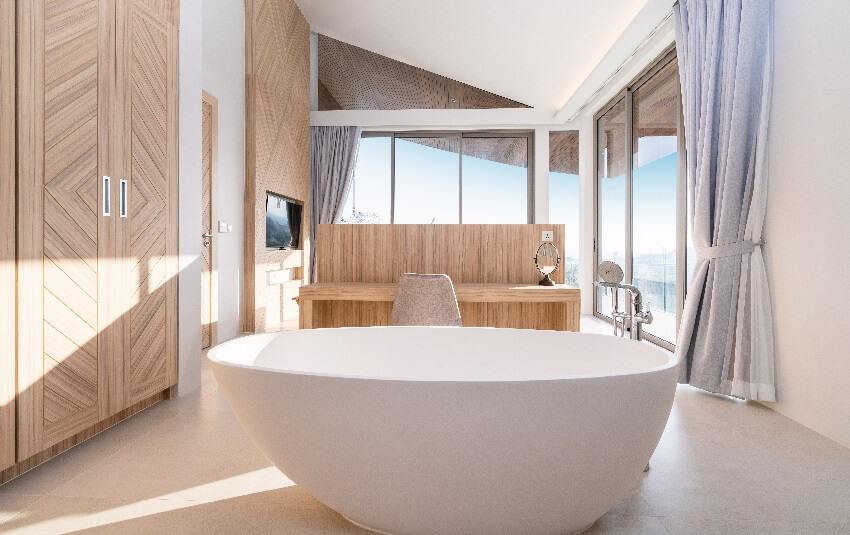 Садовая ванна в современной ванной комнате виллы с деревянными шкафами и кафельным полом