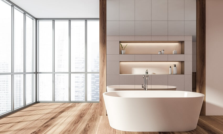 Ванная комната с отдельно стоящей ванной, панорамными окнами с деревянным полом и встроенными настенными полками