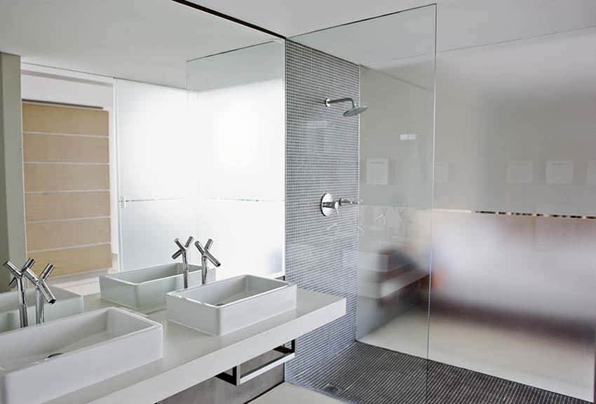 Современная ванная комната с душевой кабиной наполовину из матового стекла
