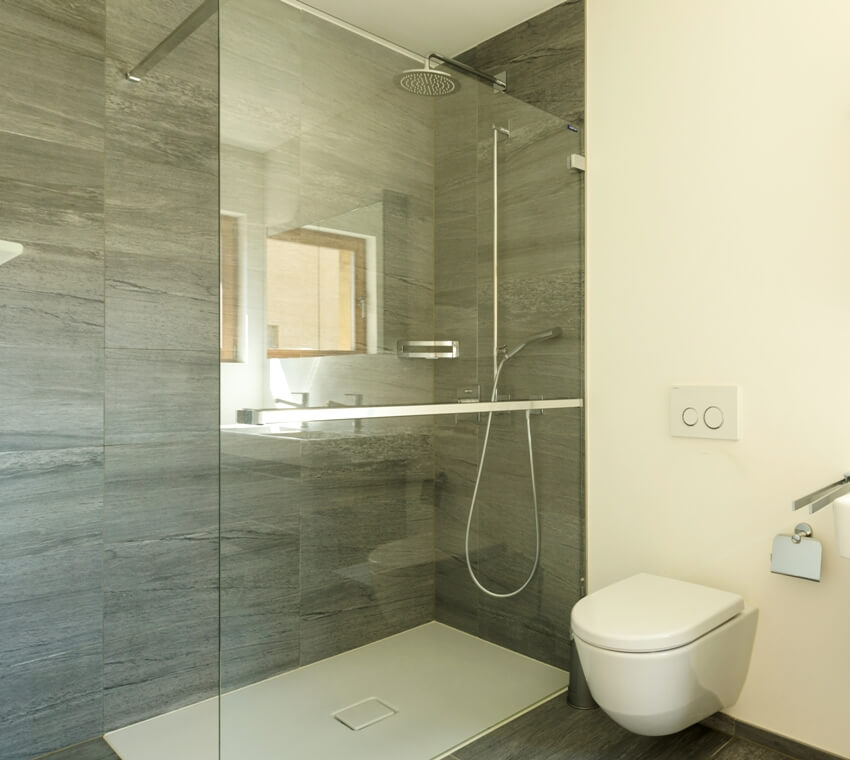 Пустой современный интерьер ванной комнаты с душем и серым камнем, похожим на стены из ламината