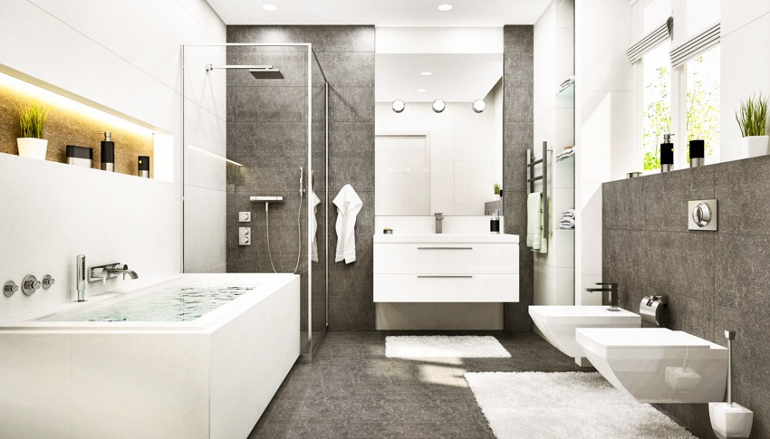 Ванная комната с ванной, туалетом, биде, зеркалом, плавающей столешницей, гранитной душевой стеной и стеклянной перегородкой.