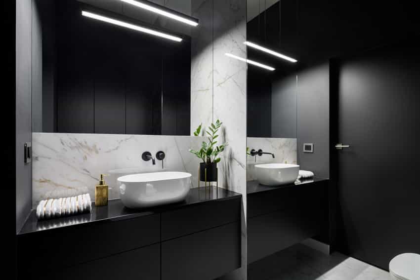 Black bathroom with countertops, sink, cabinets, and ceiling lights
