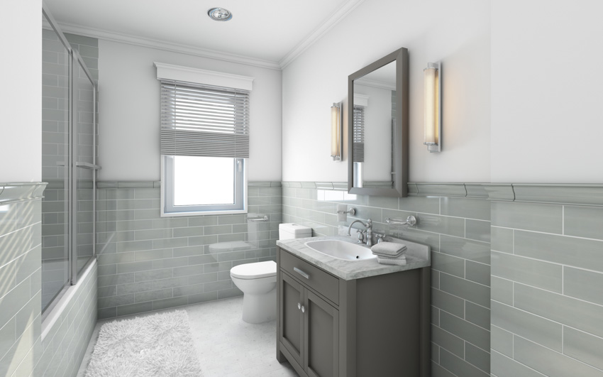 Ванная комната с серыми стенами плитки метро, ​​раковиной, зеркалом, туалетом и окном