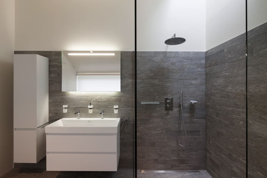 Минималистская ванная комната с душевой зоной, окном, смесителями для раковины и акцентной стеной