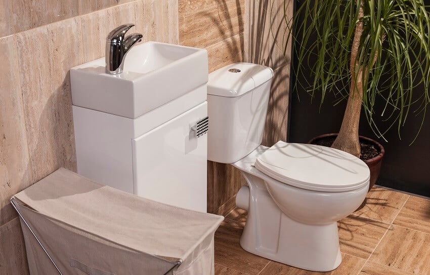 Современная ванная комната с каменными полами и стенами, раковиной, туалетом и стеллажом для хранения
