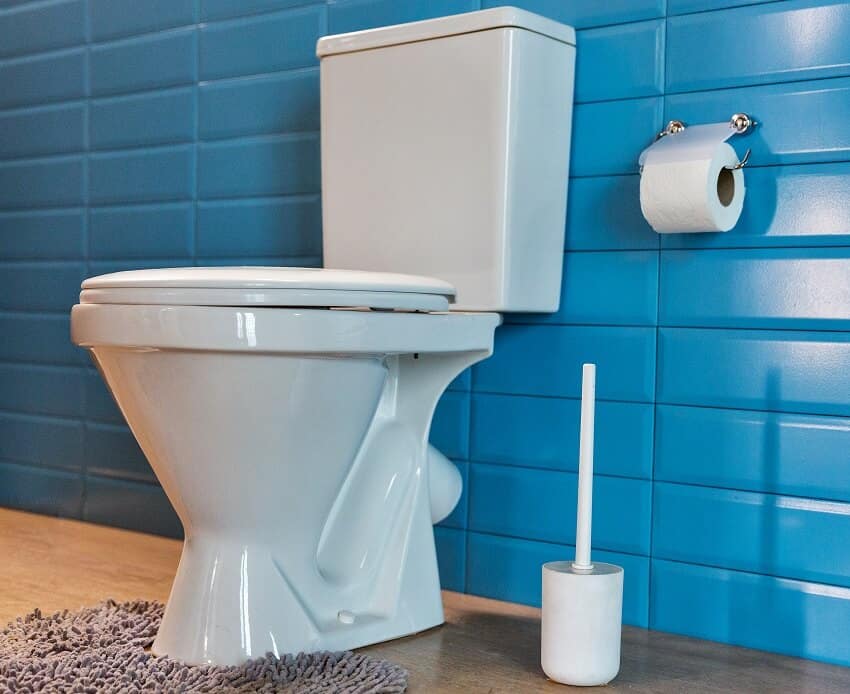 Коврик для унитаза и синяя стена, выложенная плиткой в ​​стиле метро, ​​в современной ванной комнате.