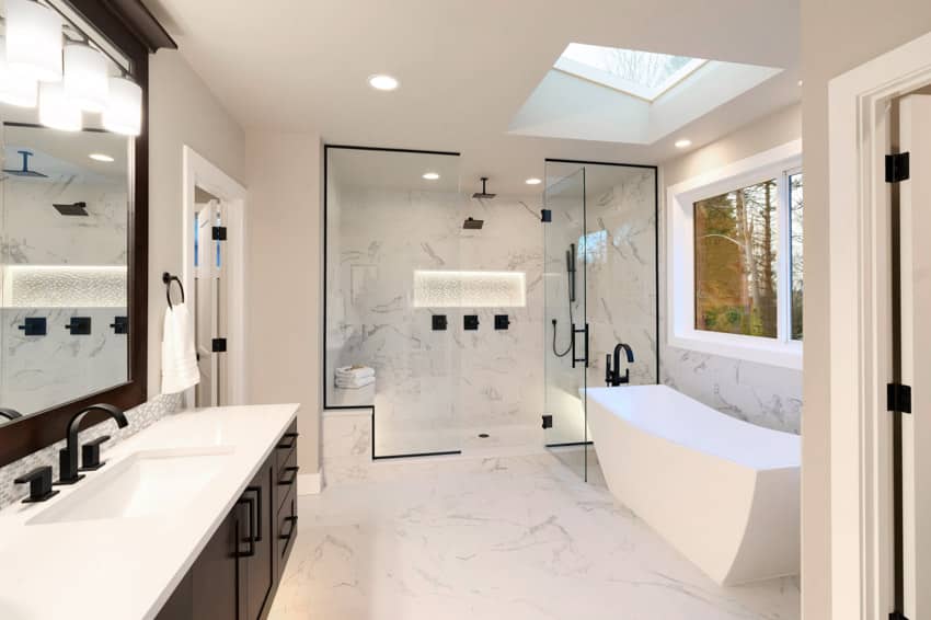 Просторная ванная комната световой люк ванна зеркало душевая стеклянная перегородка раковина столешница мраморная стена