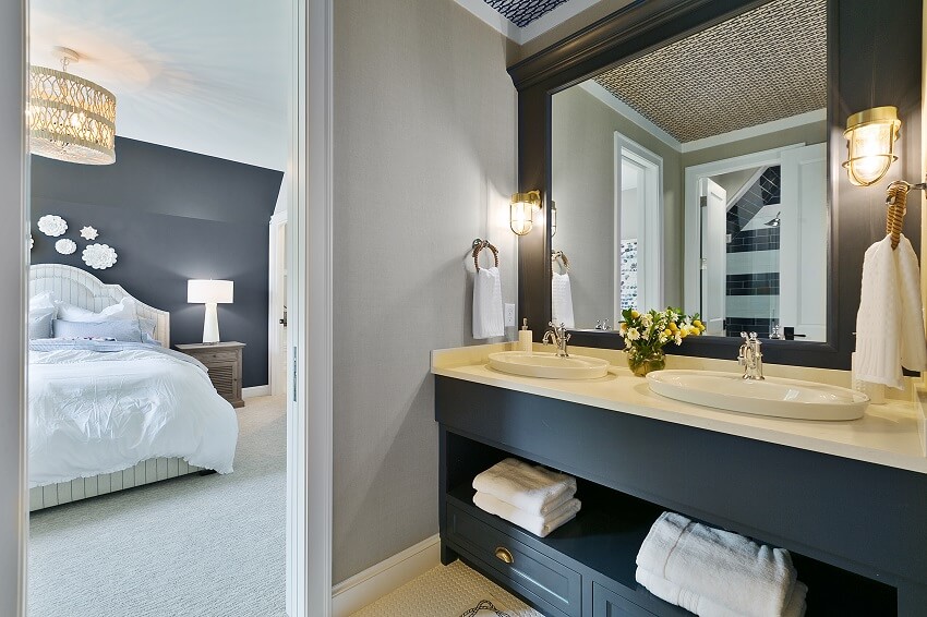 Ванная комната с открытыми полками под раковиной, косметическим зеркалом, осветительными приборами и видом на спальню