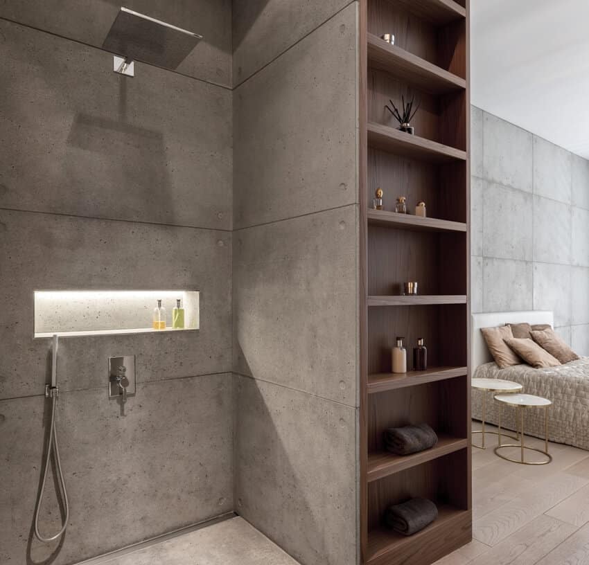 Ванная комната с современным дизайном и душем открывается в спальню с бетонной лепниной на стенах и деревянными полками посередине.