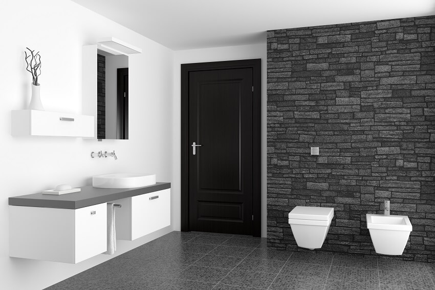 Современная ванная комната с черной стеной из искусственного камня и белым туалетом 