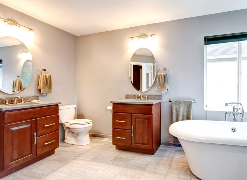 Красивый серый новый роскошный современный интерьер ванной комнаты с двумя отдельными раковинами с темными шкафами