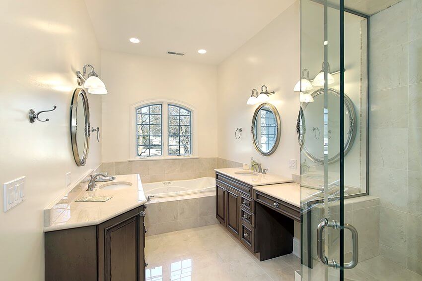 Главная ванная комната со стеклянными зеркалами для душа, ванной и темными шкафами