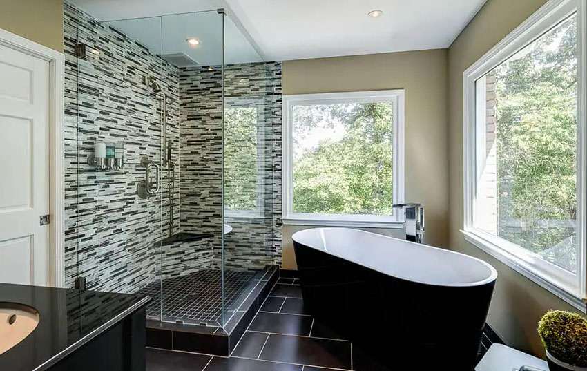Ванная комната с бескаркасными душевыми дверями, черной плиткой и панорамным окном