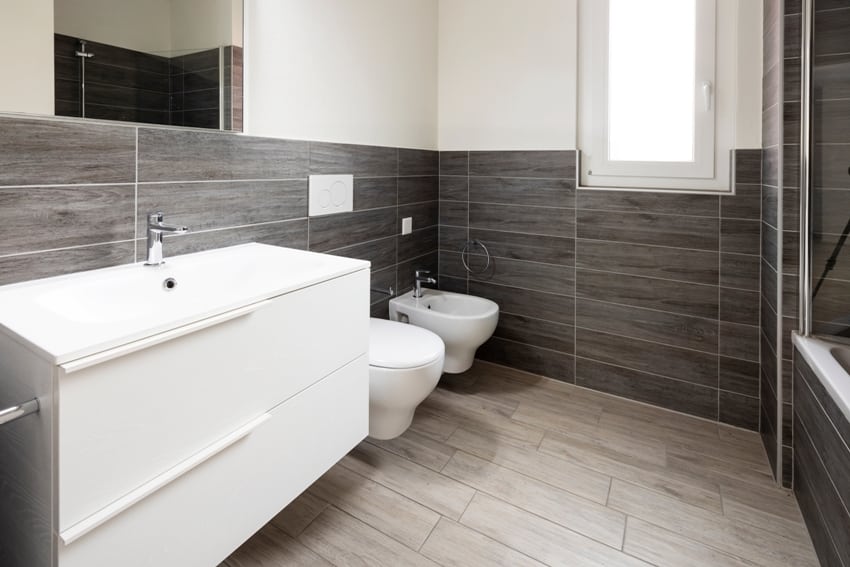 Ванная комната с элегантными минималистскими стенами, выложенными коричневой плиткой