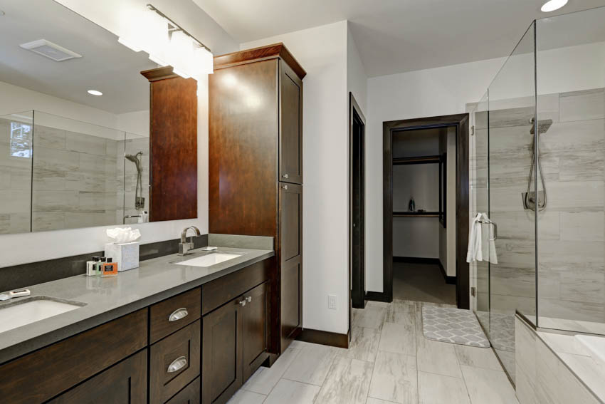 Классическая ванная комната с зеркалом на столешнице, деревянными ящиками шкафа, душевой зоной
