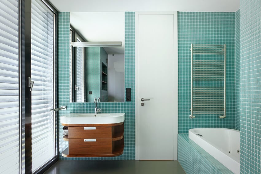 Современная ванная комната с привлекательными голубыми стенами, деревянной раковиной и ванной