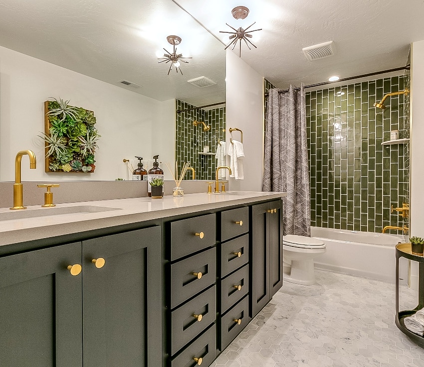 красивая ванная комната с зеленой плиткой, аксессуар для душевой стены, зеленые ящики, латунные смесители и светильники