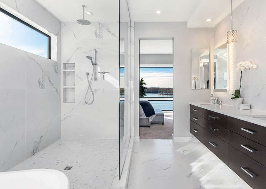Ванная комната с душевой кабиной из белого кварца, насадкой для тропического душа и коричневой плавающей раковиной с подсветкой под шкафом