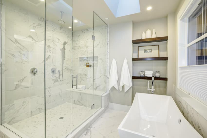 Bathroom with porcelain bathtub glass built in shower bench and wooden shelves