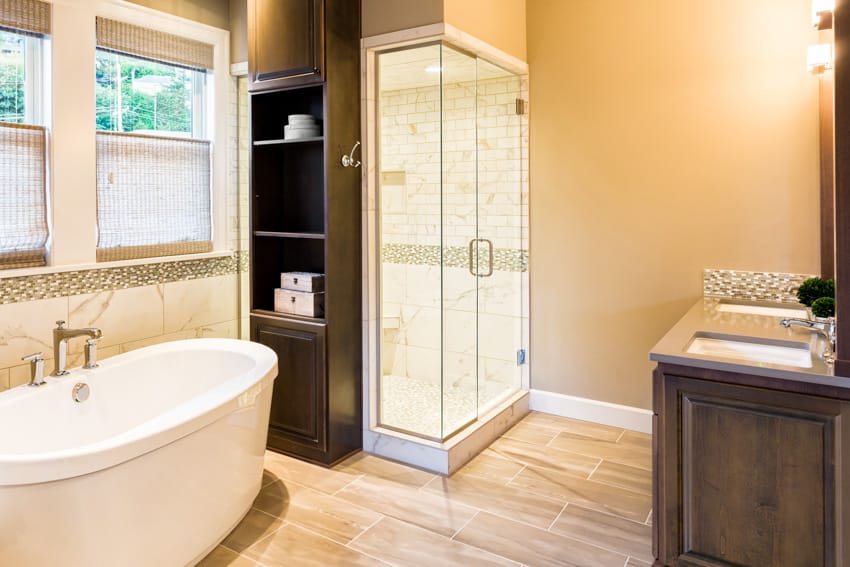 Ванная комната с деревянным полом, стеклянной дверью и ванной