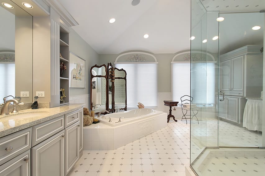 В большой ванной комнате используется светлая отделка с белой керамической плиткой и светло-серыми ромбовидными деталями.