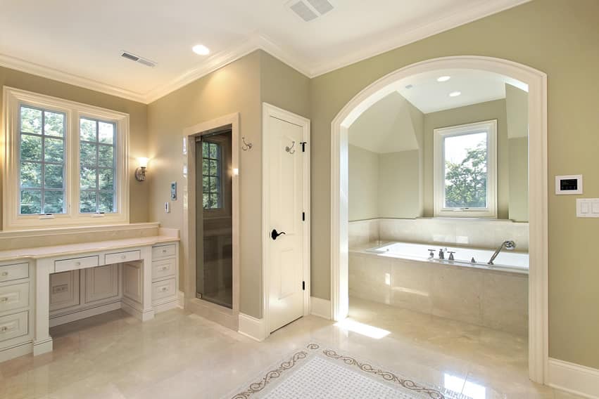 В большой ванной комнате используется светлый полированный керамогранит с белым арочным пространством для ванны.