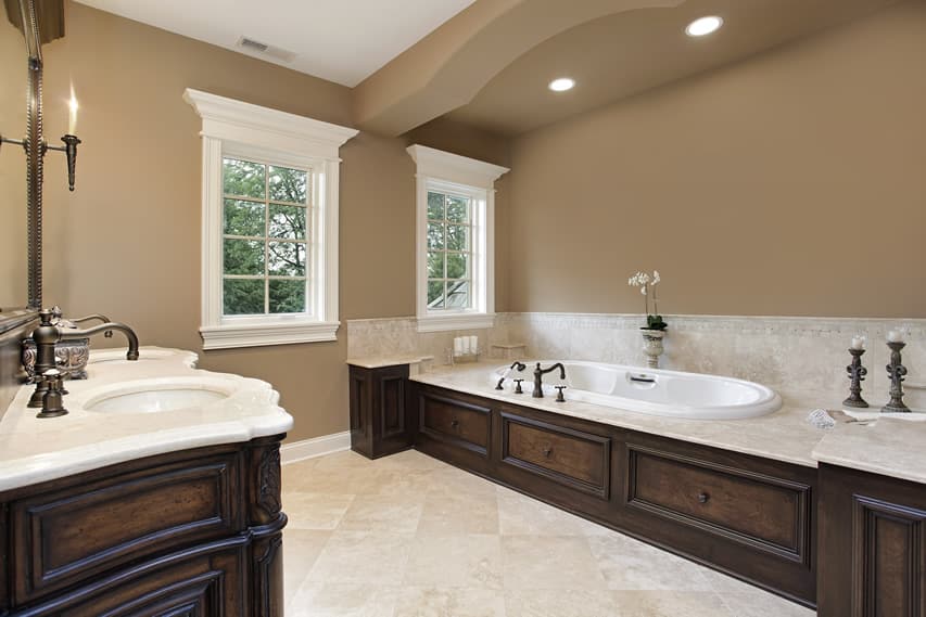 Ванная комната с теплыми коричневыми стенами и лепниной с полом из керамогранита и столешницей из белого гранита