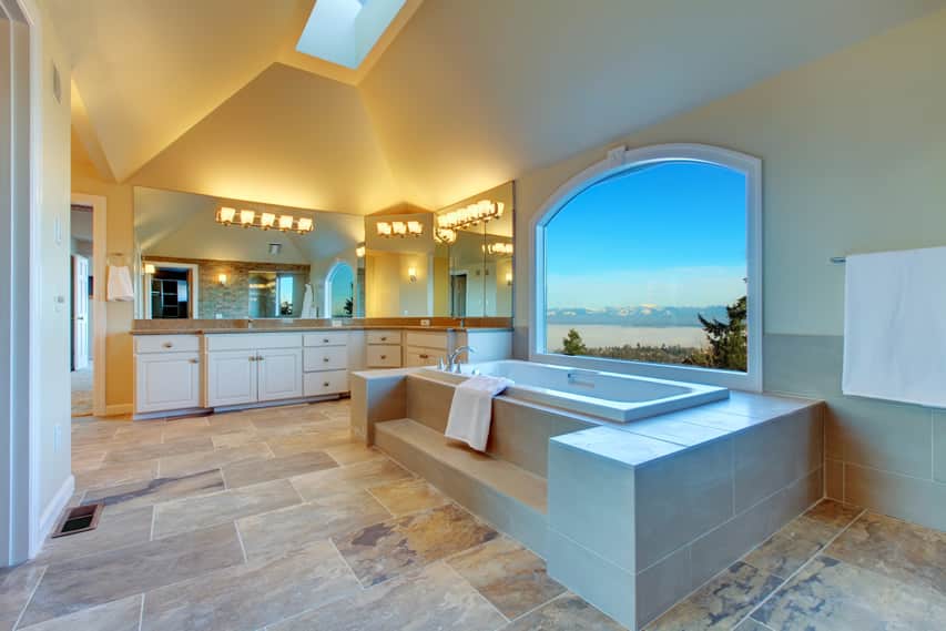 В главной ванной комнате напольная плитка из натурального сланца сочетается с теплой серой керамической плиткой для стен.