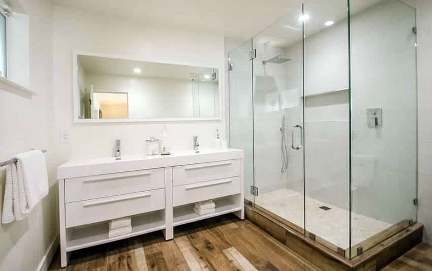 Ванная комната с современным туалетным столиком и двумя раковинами со стеклянным душем