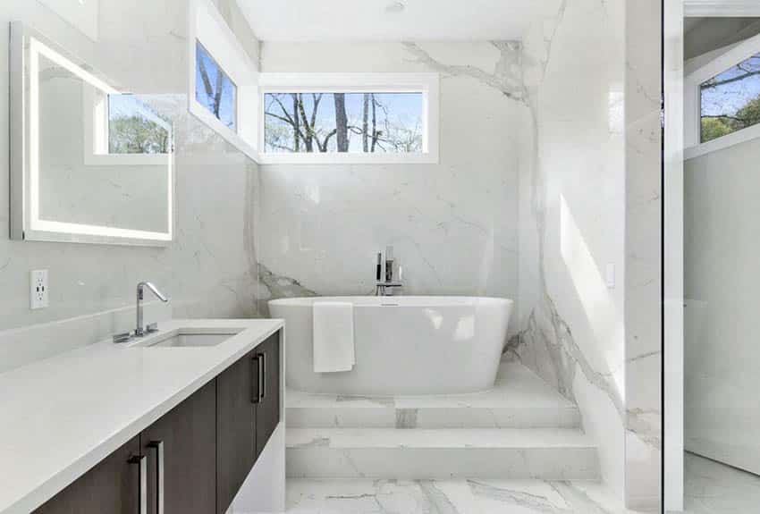 Ванная комната с белой кварцевой столешницей, отдельно стоящей ванной на пьедестале