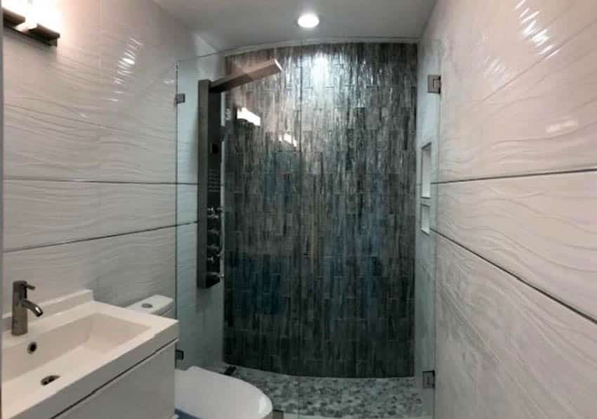 Современный душ с черной плиткой и белой волнистой настенной плиткой