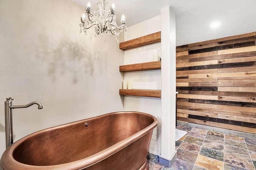 Отдельностоящая медная ванна в ванной комнате с деревянной акцентной стеной