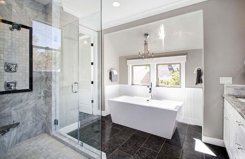 Современная ванная комната с современной ванной и черной плиткой на полу