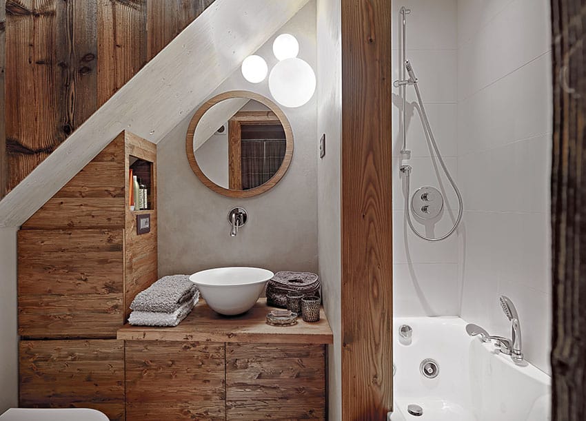 Небольшая ванная комната на чердаке с наклонным потолком и раковиной на пьедестале