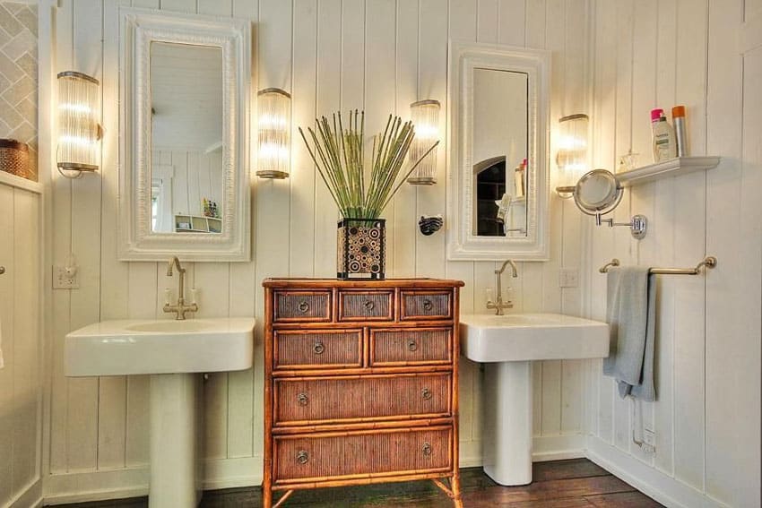 Небольшая ванная комната с центральным деревянным шкафом между двумя раковинами