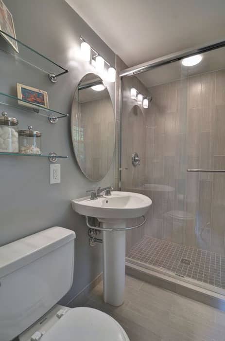 Небольшая современная ванная комната с раковиной на пьедестале, полом из керамогранита и стеклянными полками