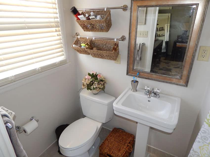 Небольшая ванная комната с настенной вешалкой для полотенец и подвесной корзиной для хранения