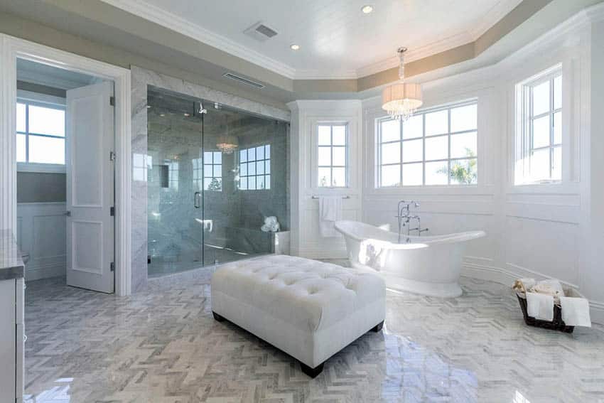 Главная ванная комната с чугунной ванной, отделанной панелями во всю стену, и стеклянной душевой кабиной.