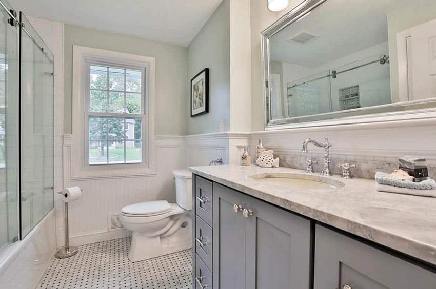 Ванная комната с белой облицовочной плиткой на полу и мраморной столешницей