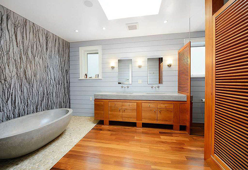Современная главная ванная комната с корабельной стеной, ванной из травертина и полом из натурального речного камня.