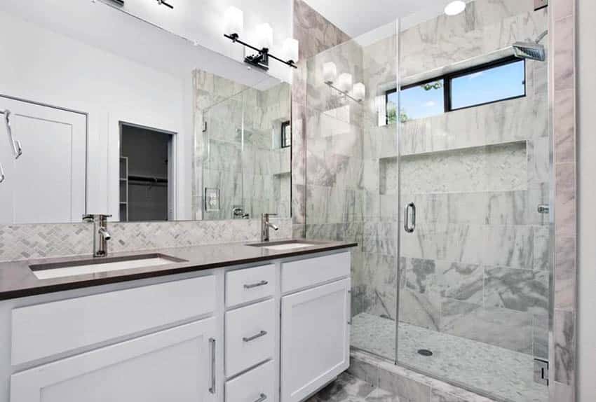 Ванная комната с мраморным полом и белой раковиной с мраморным фартуком