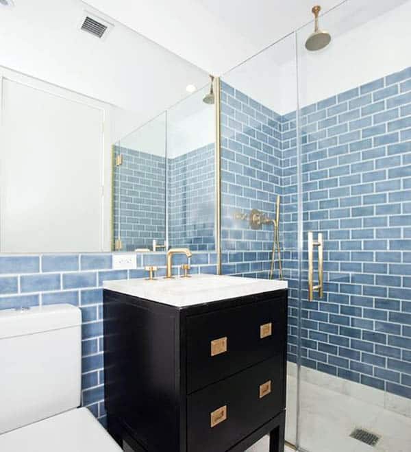 Современная ванная комната с синей керамической плиткой и золотой отделкой