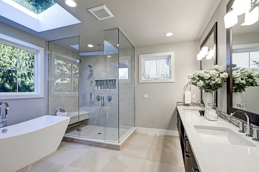 Master bathroom with dark wood vanity, arctic white quartz countertop and freestanding tub