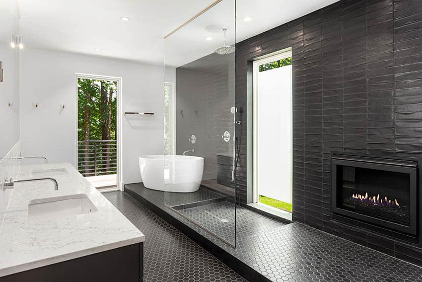 Роскошная ванная комната с черным шестигранным мозаичным напольным покрытием, душем, отдельно стоящей ванной, мраморной столешницей, газовым камином