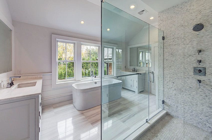 Master bathroom with large clear glass, shower door with white mosaic tile and dual vanities