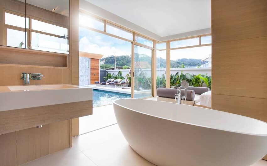 Luxury bathroom with sink, freestanding stone resin bathtub, and view of the pool